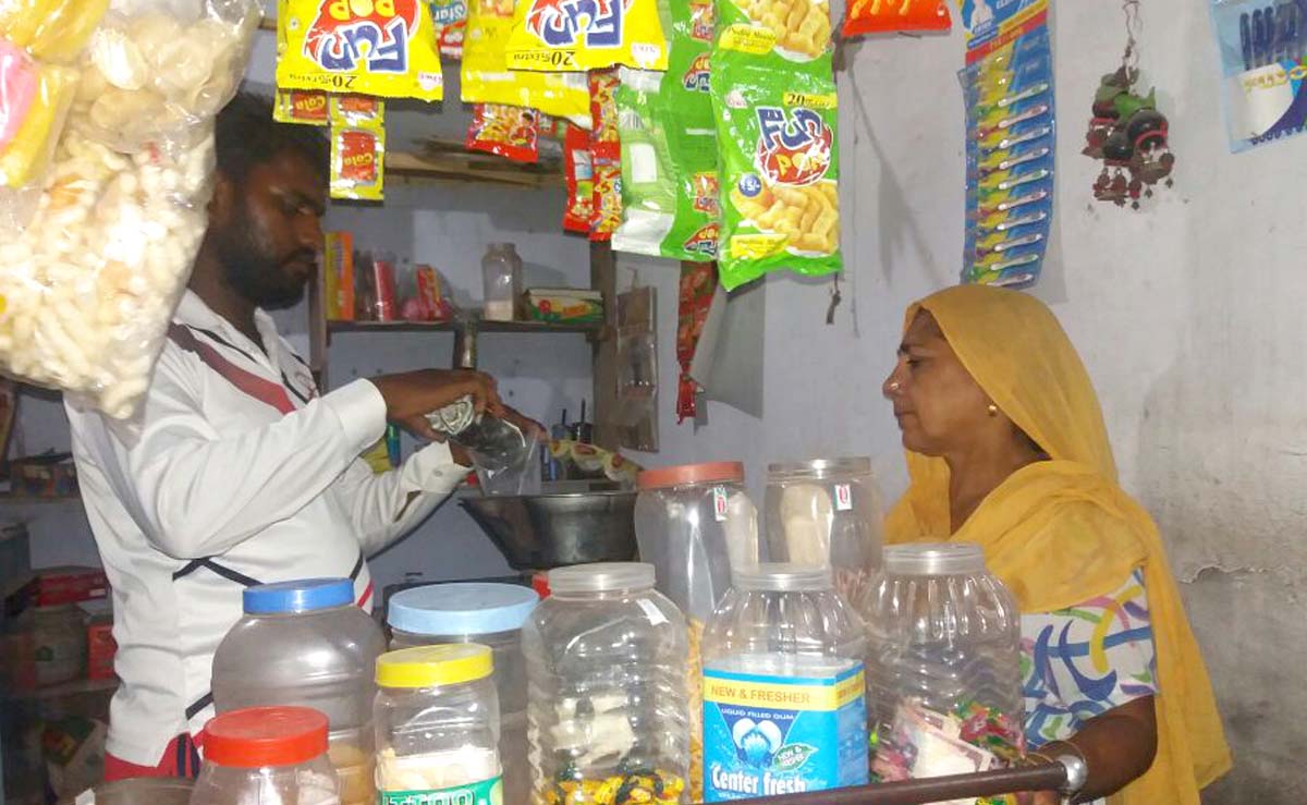Gagan Kumar at his grocery shop with customer 